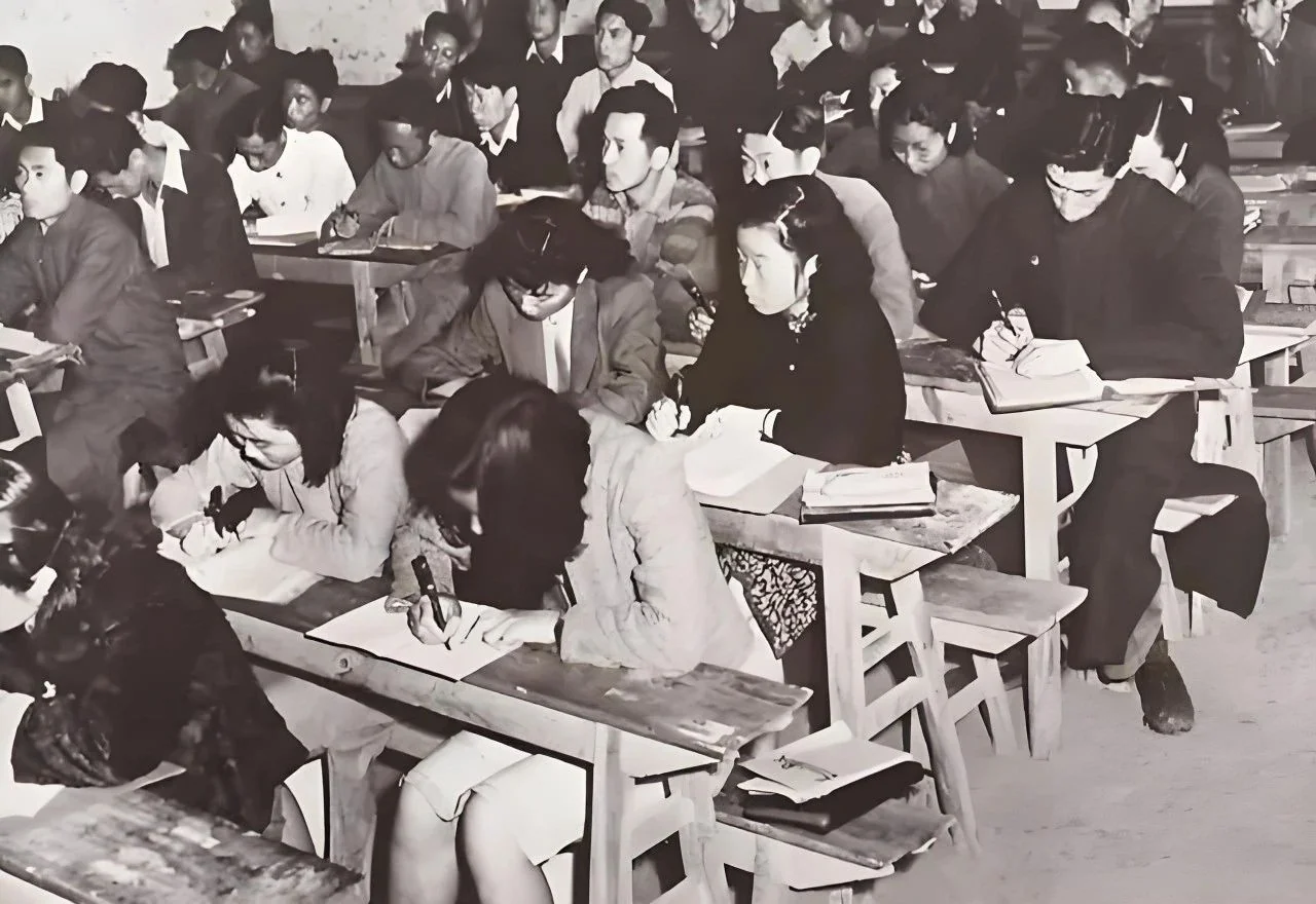 西南联大学生在教室听课，木桌木凳上伏案记笔记